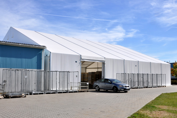 Osobní automobil před vraty lehké skladovací haly.